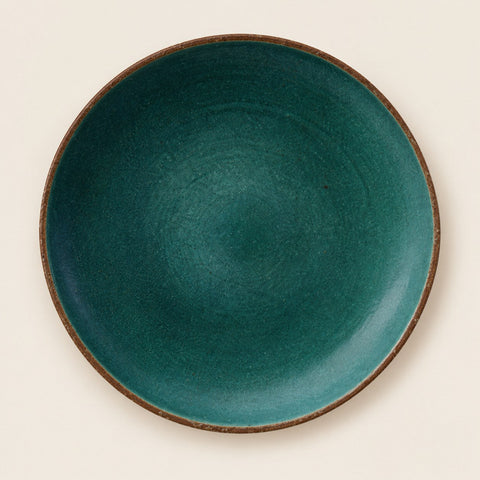 Assiette céramique artisanale verte sur fond beige