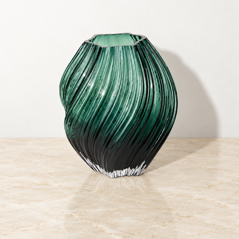 Vase en verre soufflé vert sur un plateau en marbre beige