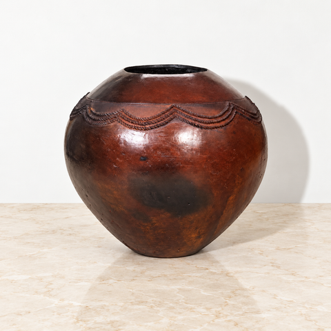 Poterie zouloue noire artisanale sur un plateau en marbre beige