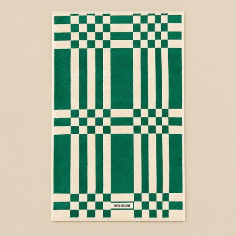 Serviette Marina verte dépliée sur fond beige