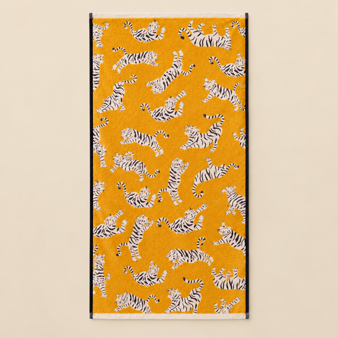 Serviettes Tigers en coton biologique dépliée sur fond beige